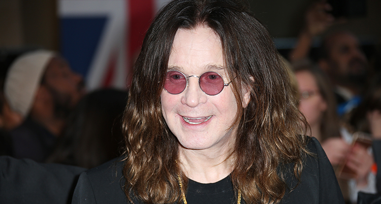 Ozzy ler mot någon. Han har utsläppt hår och runda små solglasögon.