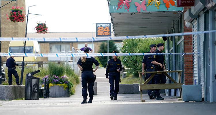 Platsen är avspärrad med tejp. Flera poliser syns.
