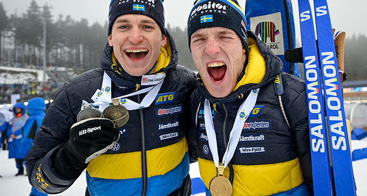 Martin och Sebastian håller om varandra och visar sina medaljer.
