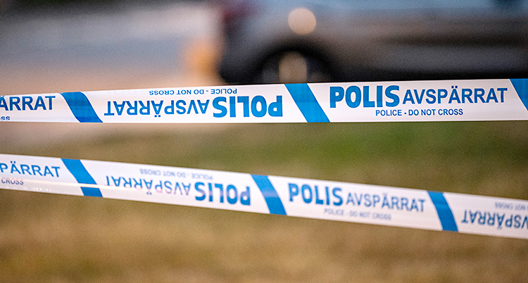 Poliser har spärrat av en plats med vita och blå band.