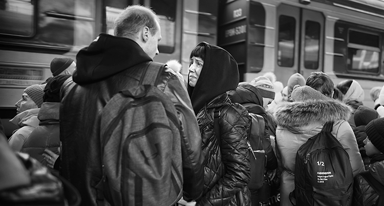 En kvinna och en man står på en station. De tittar på varann. Kvinnan gråter.