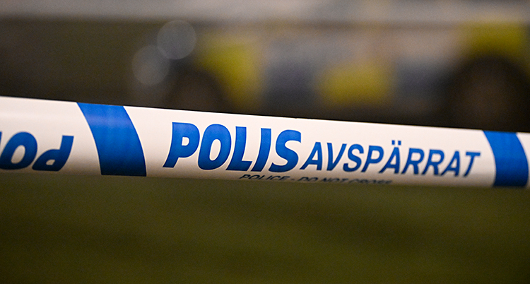Poliser har spärrat av med ett band som är blått och vitt.