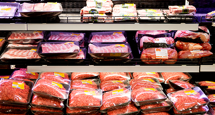 Paket med kött som ligger i en disk i en butik.