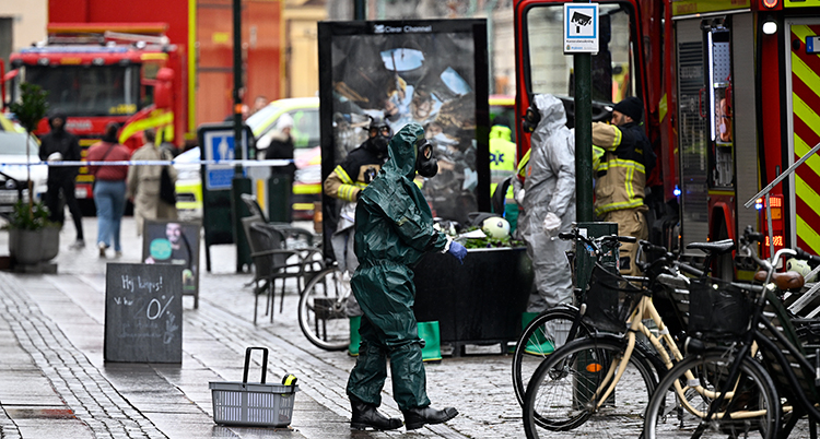 brandmän i skyddskläder på en gata i en stad.
