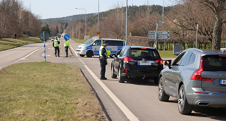 Poliser står vid en väg och stoppar bilar.