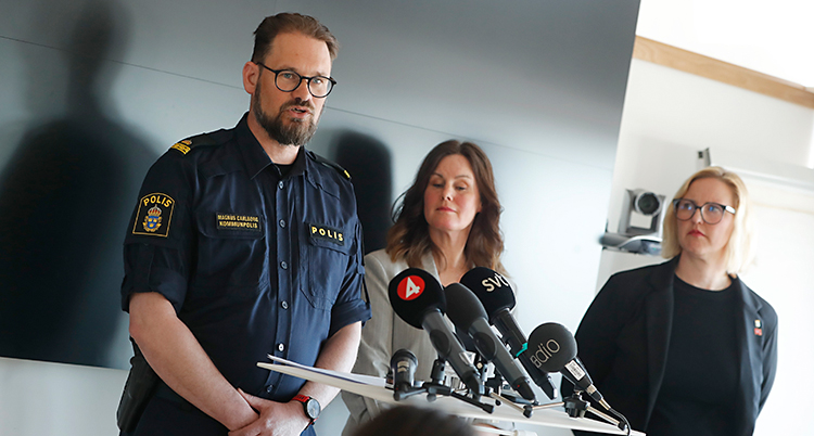 Tre personer står vid några mikrofoner.