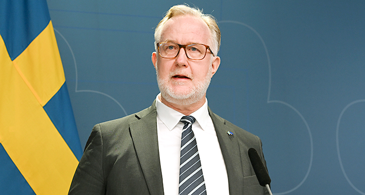 Han står och pratar på en träff med journalister.