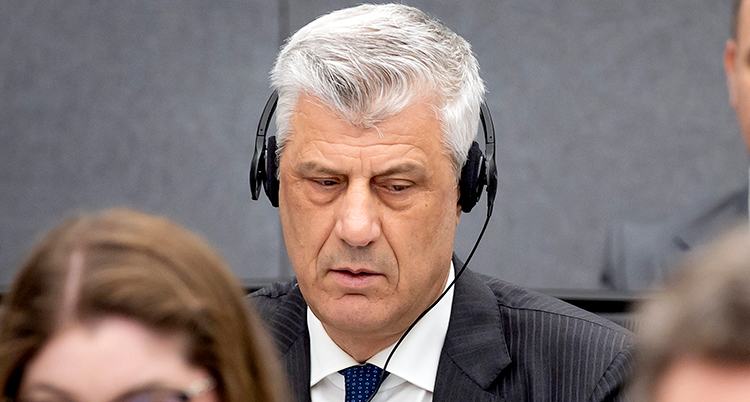 Thaci sitter med hörlurar.