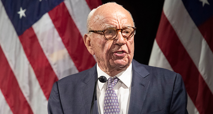 Murdoch i kostym framför amerikanska flaggan.