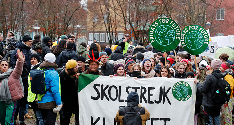 De står samlade. De har en stor skylt som det står Skolstrejk för klimatet på.