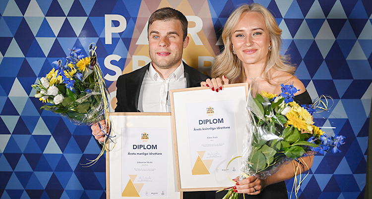 De ler mot kameran. De visar upp sina diplom och sina blommor.