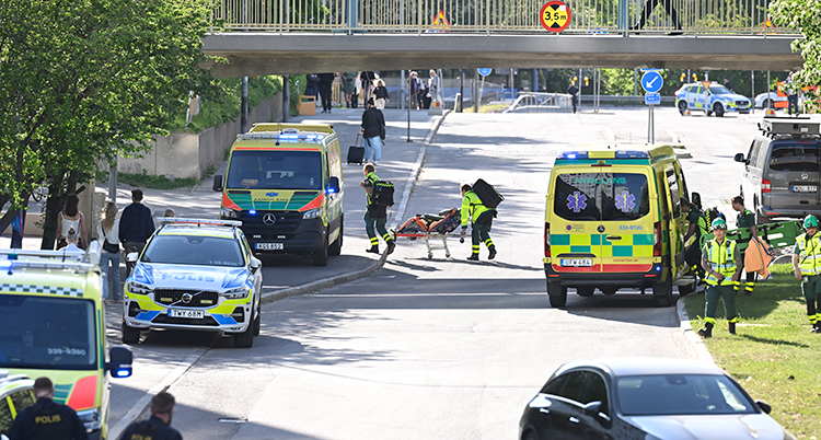 Ambulanser och poliser på en gata.