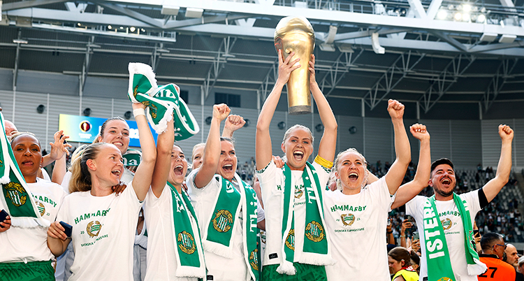 Spelare jublar och håller upp en pokal.