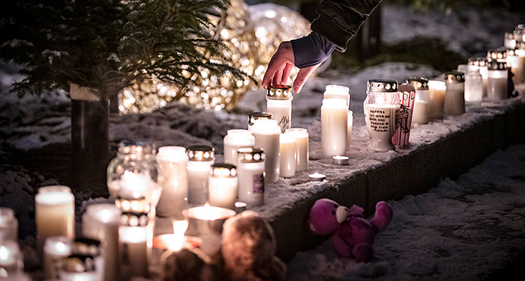 Det är vinter. Det står massor av tända ljus på ett torg.