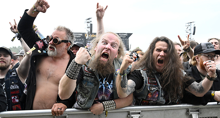 Några hårdrockare som röjer längst fram på en konsert.
