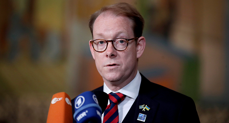 Tobias Billström pratar i två mikrofoner.