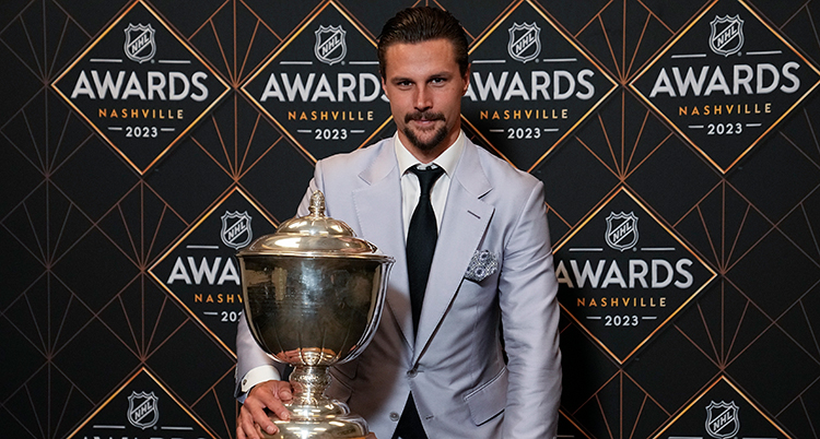 Karlsson står med en stor pokal.