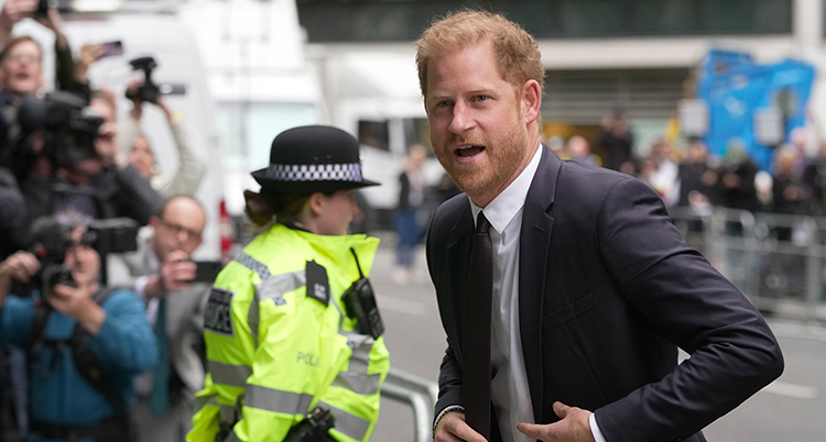 Harry på väg in till domstolen. Folk och en polis syns i bakgrunden.