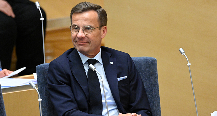 Ulf Kristersson i halvfigur. Han ler.
