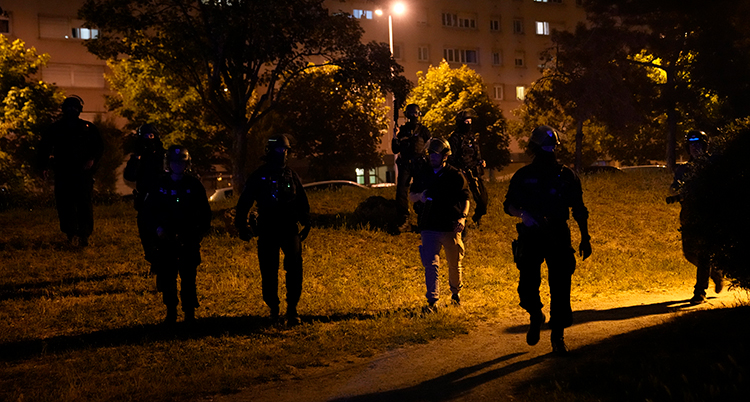 Flera poliser i hjälmar i mörker.