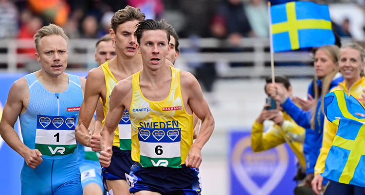 Han springer i gult linne. Flera löpare springer bakom.