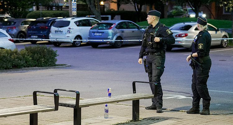 Två poliser vid en parkering.