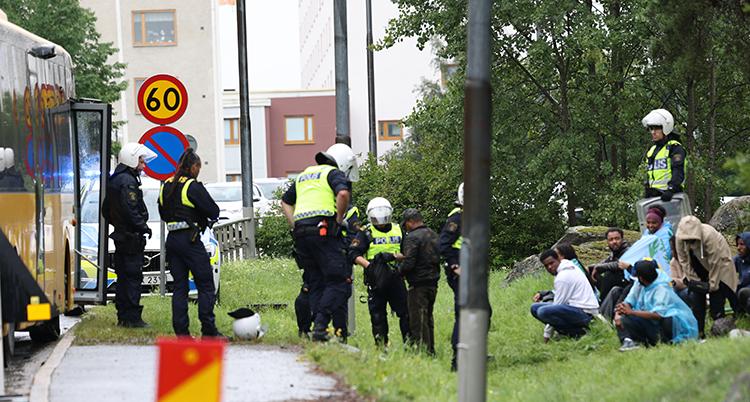 Flera poliser står på en väg.