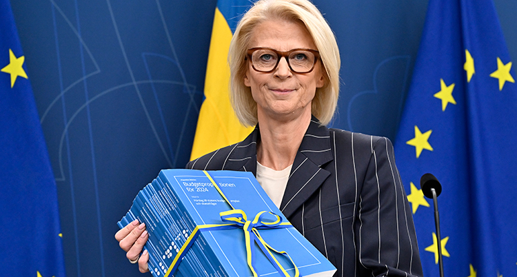 Elisabeth Svantesson håller en bunt papper i händerna. Det är budgeten.