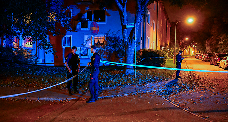 Det är mörkt. Flera poliser sätter upp tejp.