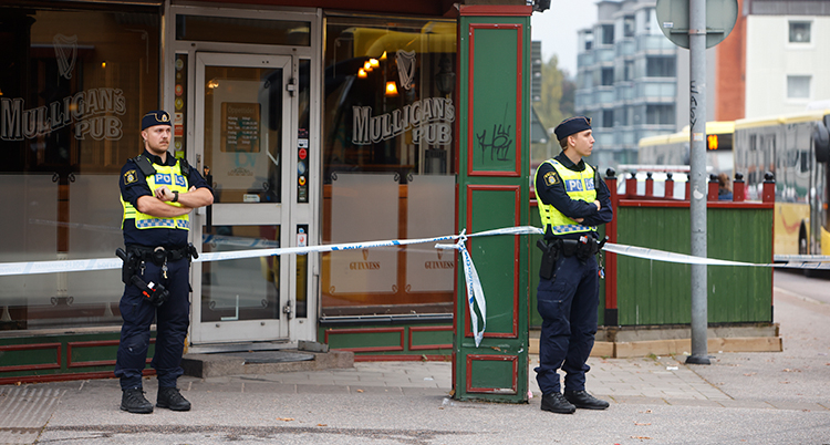 Två står utanför. De har satt upp tejp.