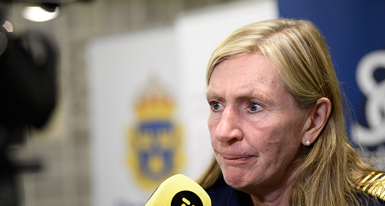 Hon har en mikrofon framför sig.