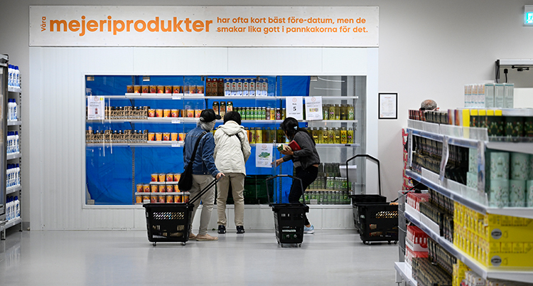 Tre står framför en hylla med mjölk.