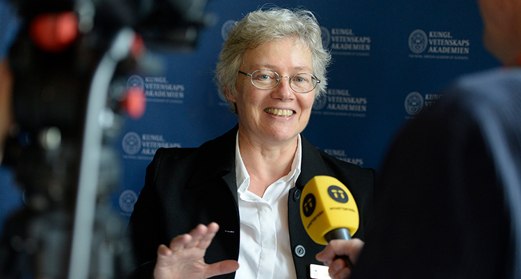 Anne L'Huillier talar i en mikrofon.