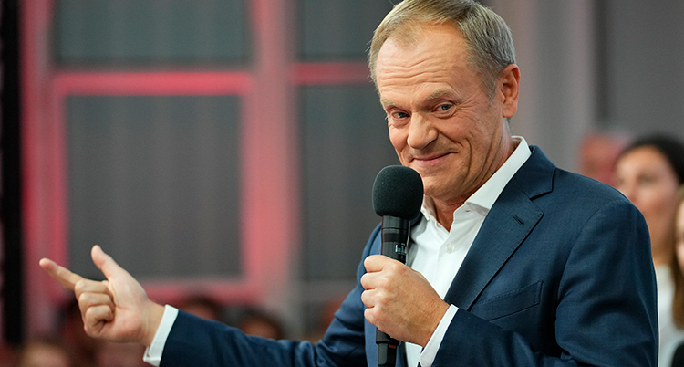 Tusk håller upp en hand och pekar åt höger.