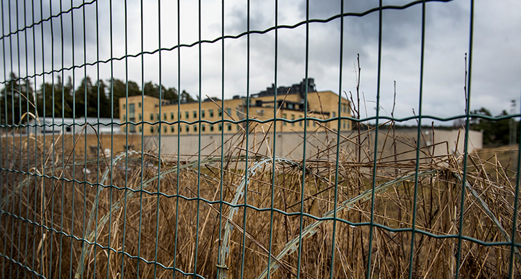 Ett stort hus syns bakom ett stängsel.