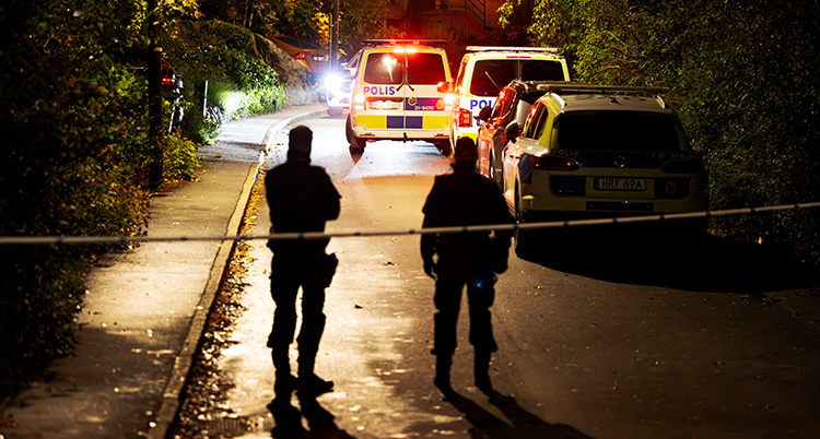 Poliser på en mörk gata.