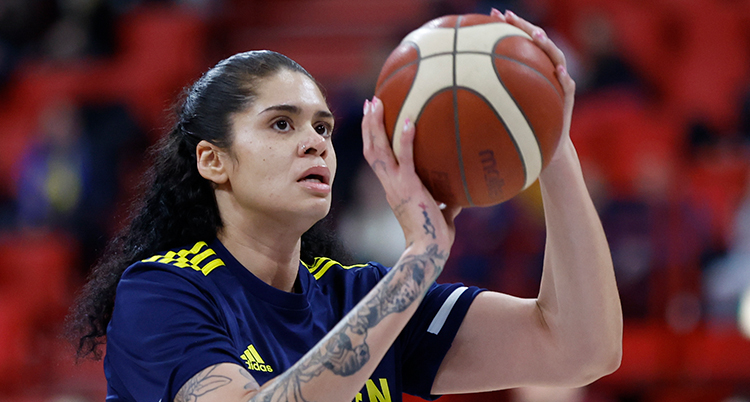 Hon håller i en basketboll och siktar för att skjuta iväg den.