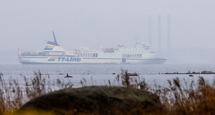 Fotot är tagen från stranden, ut mot havet. Där ligger en stor båt, en färja.