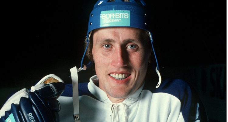 Glad spelare med blå ishockeyhjälm.