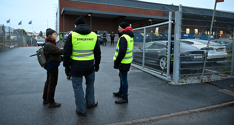 Personer i gula västar utanför ett stort hus.