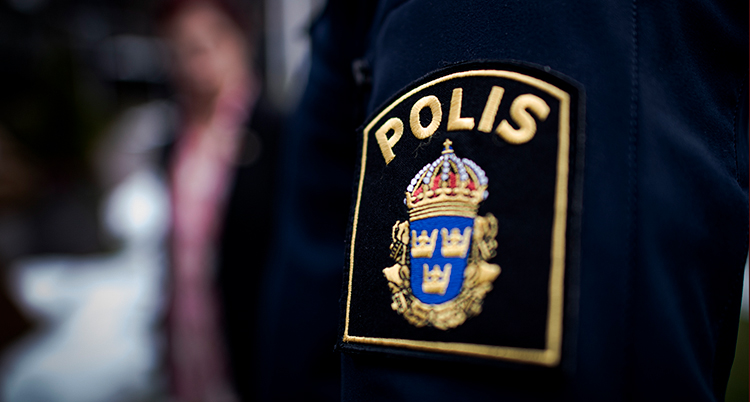 En nära bild på ett märke som det står polis på.