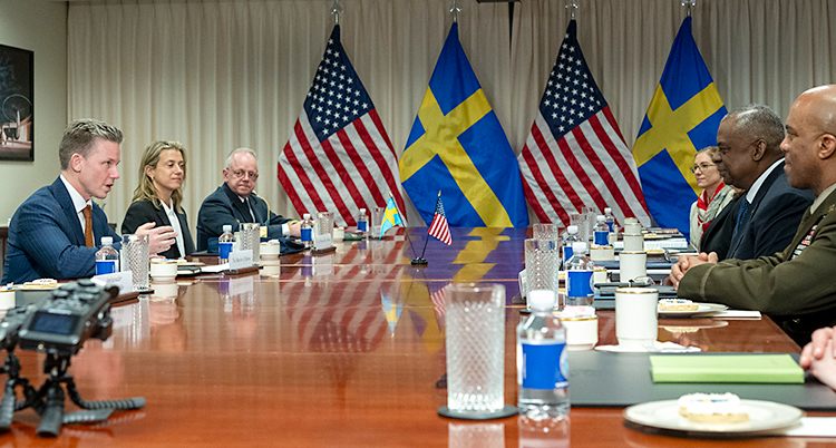 Flera personer sitter runt ett bord och pratar.