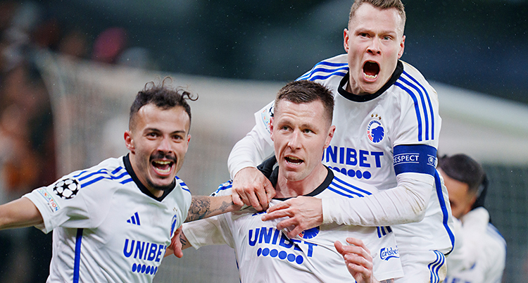 Tre spelare som jublar och kramas i en match i fotboll.