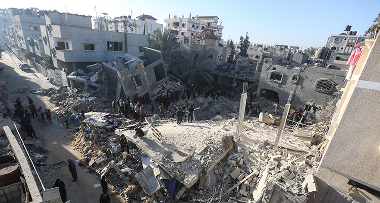 En bild på trasiga hus gator i Gaza. Bilden är tagen ovanifrån. Folk står på marken.