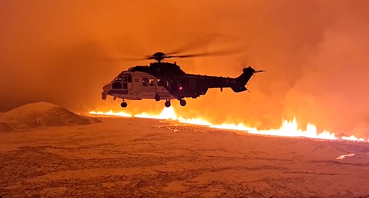 En helikopter syns i luften. En spricka med het lava syns i marken.
