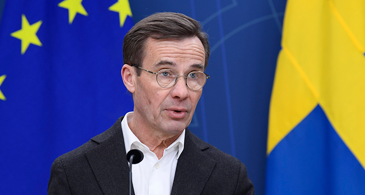 Han står framför en mikrofon.