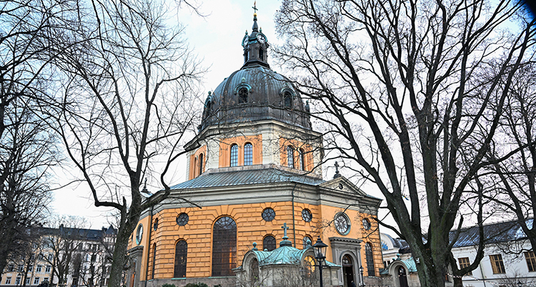 Kyrka med orangegul fasad och hög kupol.