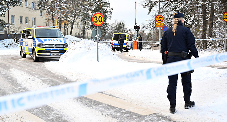 Polisbil, polis och ett blått polisband över vägen.