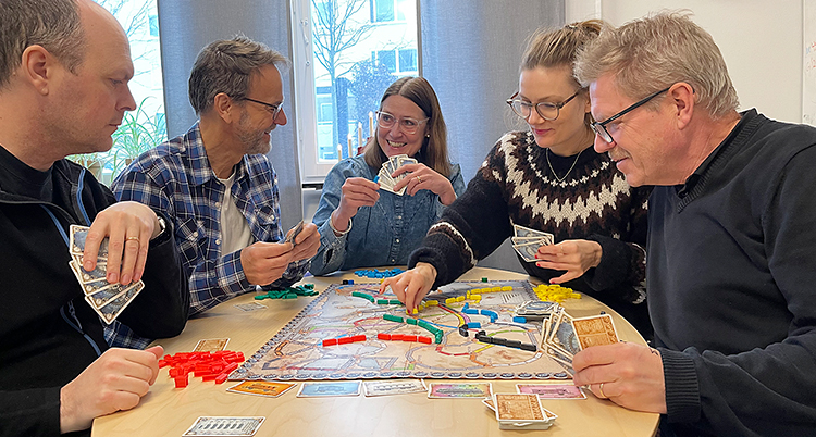 Flera personer spelar vid ett bord.