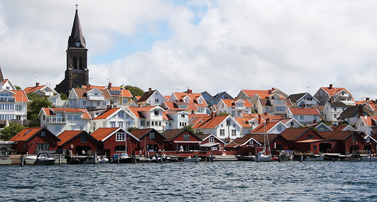 Många hus och bryggor syns vid vattnet.